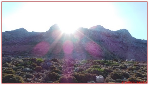 De zon piept de bergwand over